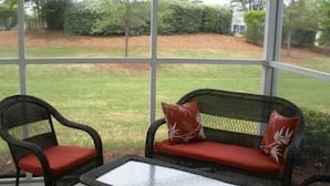 A patio with wicker furniture and a glass table. - 2314 The Havens (North Myrtle Beach)