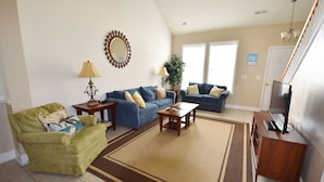A living room with a sofa, armchair, coffee table, lamp, and TV. - 2314 The Havens (North Myrtle Beach)
