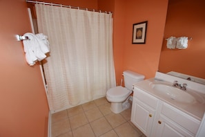 A bathroom with a toilet, sink, and shower curtain.