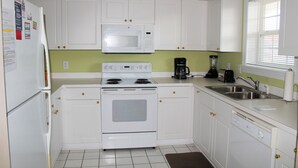 A kitchen with white cabinets, a microwave, stove, dishwasher, and a sink.