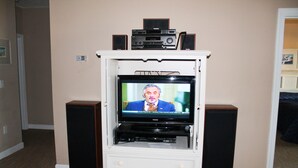 A television on a white entertainment center with speakers on either side.