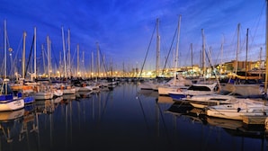 Un puerto deportivo al atardecer con numerosos barcos amarrados.