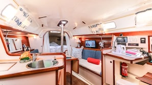 Un espacio interior compacto con kitchenette, zona de estar y baño pequeño.