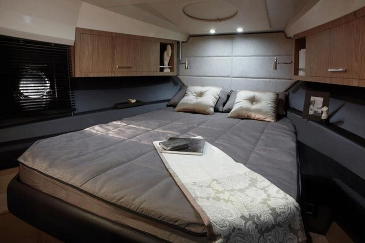 Un dormitorio pequeño con cama, mesita de noche y cabecera.