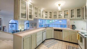 A kitchen with white cabinets, a dishwasher, and a coffee maker.
