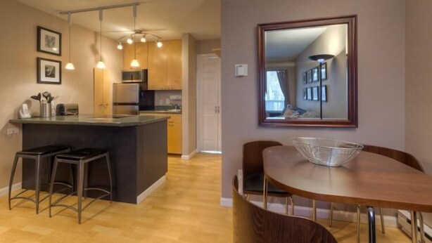 A modern kitchen with a central island, bar stools, and pendant lighting.