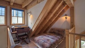 A loft bedroom with a slanted ceiling, a desk, a chair, and a bed. - El Diente A 2 Bedroom Holiday home By Accommodations in Telluride (Telluride)