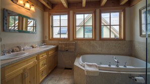 A bathroom with wooden cabinets, a large bathtub, and three windows. - El Diente A 2 Bedroom Holiday home By Accommodations in Telluride (Telluride)