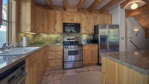 A kitchen with wooden cabinets, stainless steel appliances, granite countertops, and a built-in oven. - El Diente A 2 Bedroom Holiday home By Accommodations in Telluride (Telluride)