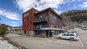 A multi-story building with a stone facade and a balcony.