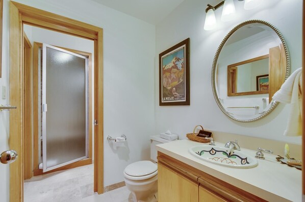 Une salle de bain avec des toilettes, un lavabo et un miroir.