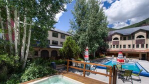 En trädgård med en bubbelpool, en swimmingpool och utomhusmöbler.