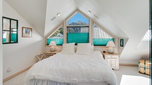 A bedroom with a large bed, two bedside tables, a window with a view of mountains, and a skylight. - Madison Pacific 1 Bedroom Condo By Accommodations in Telluride (Telluride)