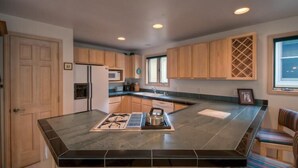 A modern kitchen with wooden cabinets, a central island, and built-in appliances. - Madison Pacific 1 Bedroom Condo By Accommodations in Telluride (Telluride)
