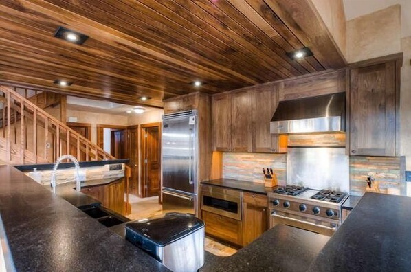 Una cocina moderna con armarios de madera, electrodomésticos de acero inoxidable y encimera de granito.