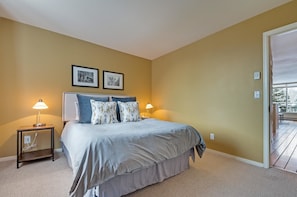 A bedroom with a bed, two bedside lamps, a nightstand, and a door leading to a balcony. - Muscatel Flats 19 1 Bedroom Condo By Accommodations in Telluride (Telluride)