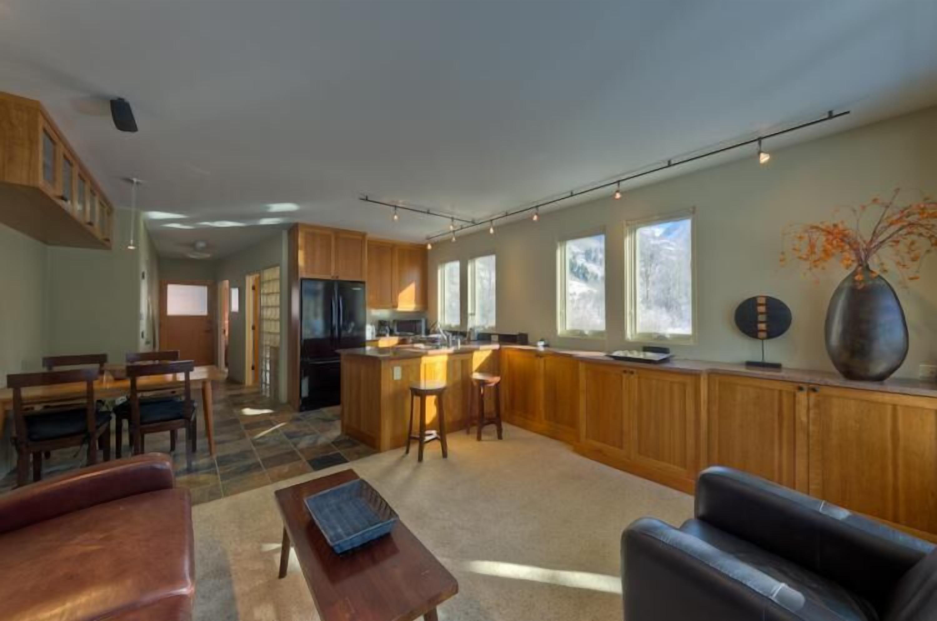 A spacious living area with a kitchen, dining table, and seating.