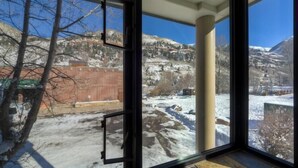 A room with large windows offering a view of a snowy landscape and mountains. - Muscatel Flats 2 1 Bedroom Condo By Accommodations in Telluride (Telluride)