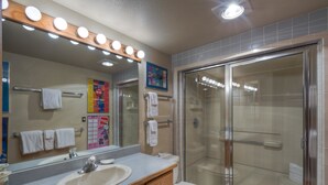 Une salle de bain avec un lavabo, un miroir et une douche.