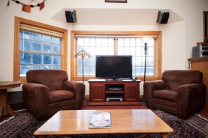 Relax in this inviting living room with a large flat-screen TV, two comfortable armchairs, and a coffee table.
