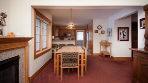 A dining area with a wooden table and chairs, a chandelier, and a fireplace. - Sundance 302 2 Bedroom Condo By Accommodations in Telluride (Telluride)