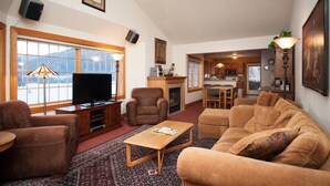 A living room with a fireplace, a television, and a sofa. - Sundance 302 2 Bedroom Condo By Accommodations in Telluride (Telluride)