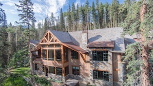 A large, multi-story log cabin with a stone foundation, surrounded by a forest. - Timber Creek 10 Bedroom Holiday home By Accommodations in Telluride (Telluride)