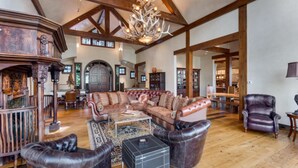 A spacious living room with a large sectional sofa, leather armchairs, and a chandelier. - Timber Creek 10 Bedroom Holiday home By Accommodations in Telluride (Telluride)