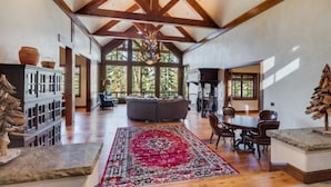 A spacious living area with a high ceiling, wooden beams, a large rug, and a fireplace. - Timber Creek 10 Bedroom Holiday home By Accommodations in Telluride (Telluride)