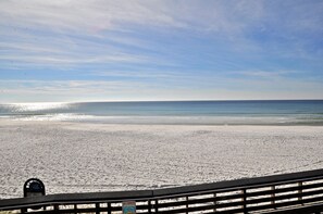 Ein Strand mit einer Holzpromenade, die zum Wasser führt.