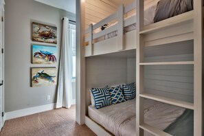 Habitación con literas y vista al pasillo, con obras de arte en la pared.