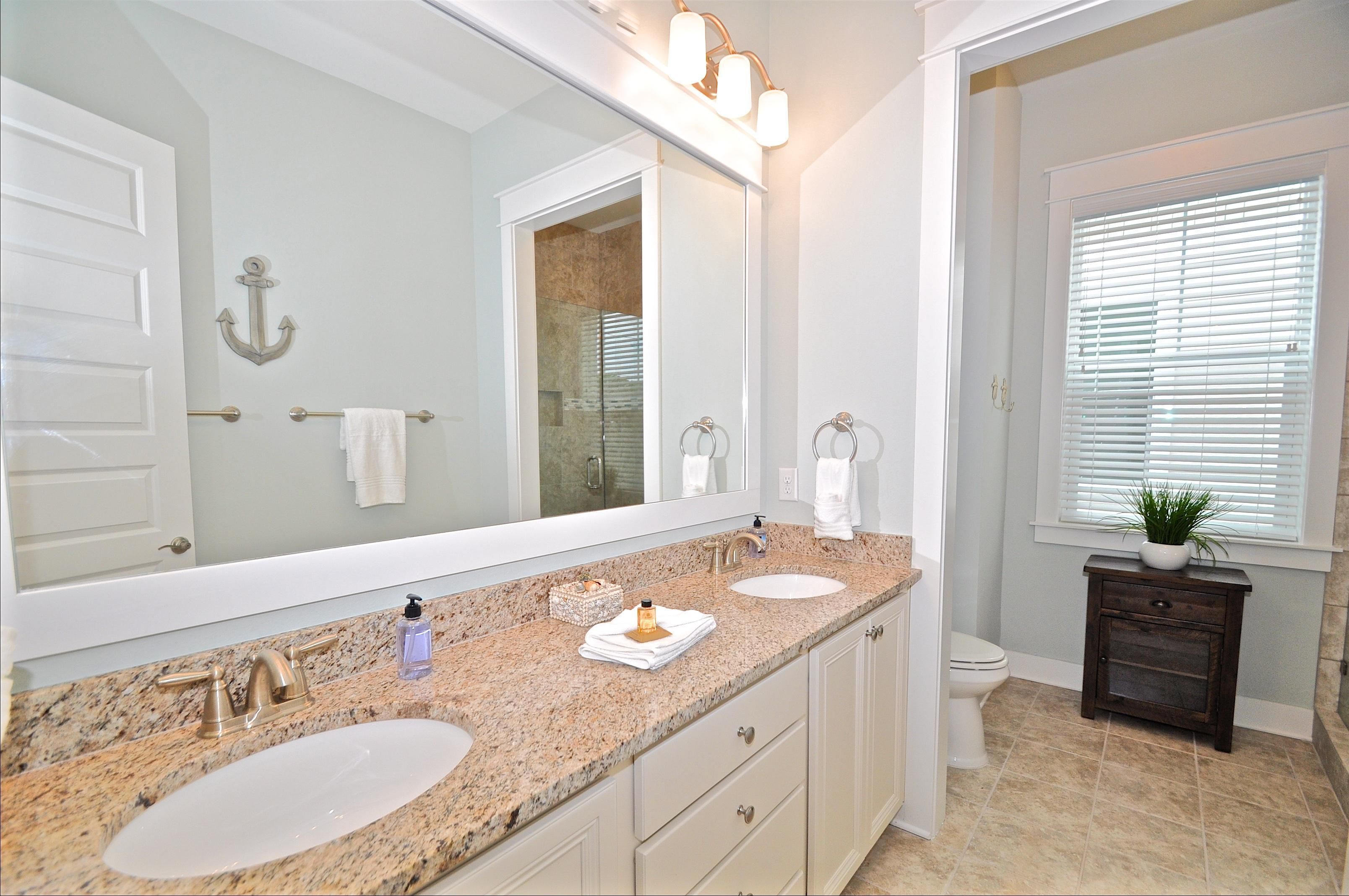 A bathroom with two sinks, a large mirror, and a vanity with drawers.