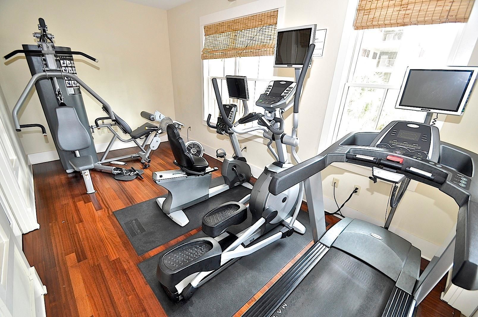 A gym with cardio machines, weight machines, and a treadmill.