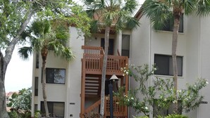A building with a brick pathway leading to a wooden staircase. - Cove II 822F 2 Bedroom Condo By Midnight Cove II (Siesta Key)