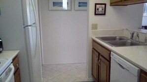 A kitchen with a refrigerator, dishwasher, and sink. - Cove II 833F 2 Bedroom Condo By Midnight Cove II (Siesta Key)
