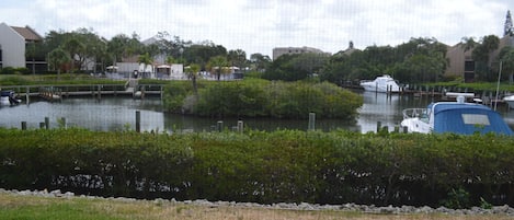A marina with boats docked, surrounded by greenery and buildings in the background.