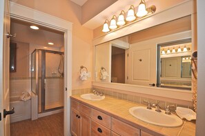 A bathroom with a walk-in shower, two sinks, a large mirror, and a towel rack. - Observation Point 454 456 2 Bedroom Condo By Coastal Dreamin (Miramar Beach)