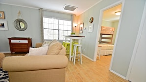 A cozy living room with a sofa, a wooden dresser, and a window with blinds. - Grayton Beach Grayt Escape 2 Bedroom Holiday Home By Coastal Dreamin (Santa Rosa Beach)