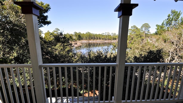 A wooden deck with white railings overlooking a lake surrounded by trees. - Old Florida Village Sea Psalm 4 Bedroom Holiday Home By Coastal Dreamin (Santa Rosa Beach)