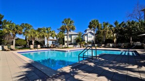 A swimming pool with a tiled deck, palm trees, and a building in the background. - Old Florida Village Sea Psalm 4 Bedroom Holiday Home By Coastal Dreamin (Santa Rosa Beach)
