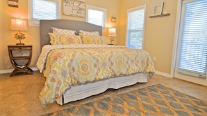 A bedroom with a large bed, two bedside tables with lamps, a patterned rug, and a window with blinds. - Old Florida Village Sea Psalm 4 Bedroom Holiday Home By Coastal Dreamin (Santa Rosa Beach)