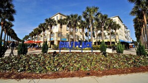 A hotel with a 'CIFLEPLACE' sign, surrounded by palm trees and a landscaped garden. - Six Palms Dreamin 2 Bedroom Condo By Coastal Dreamin (Santa Rosa Beach)