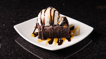 Un postre en un plato blanco con salsa de chocolate.