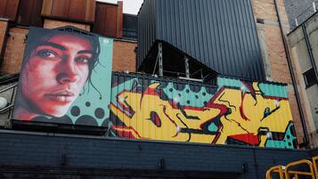 A building with a large mural on its side, featuring abstract and colorful artwork.
