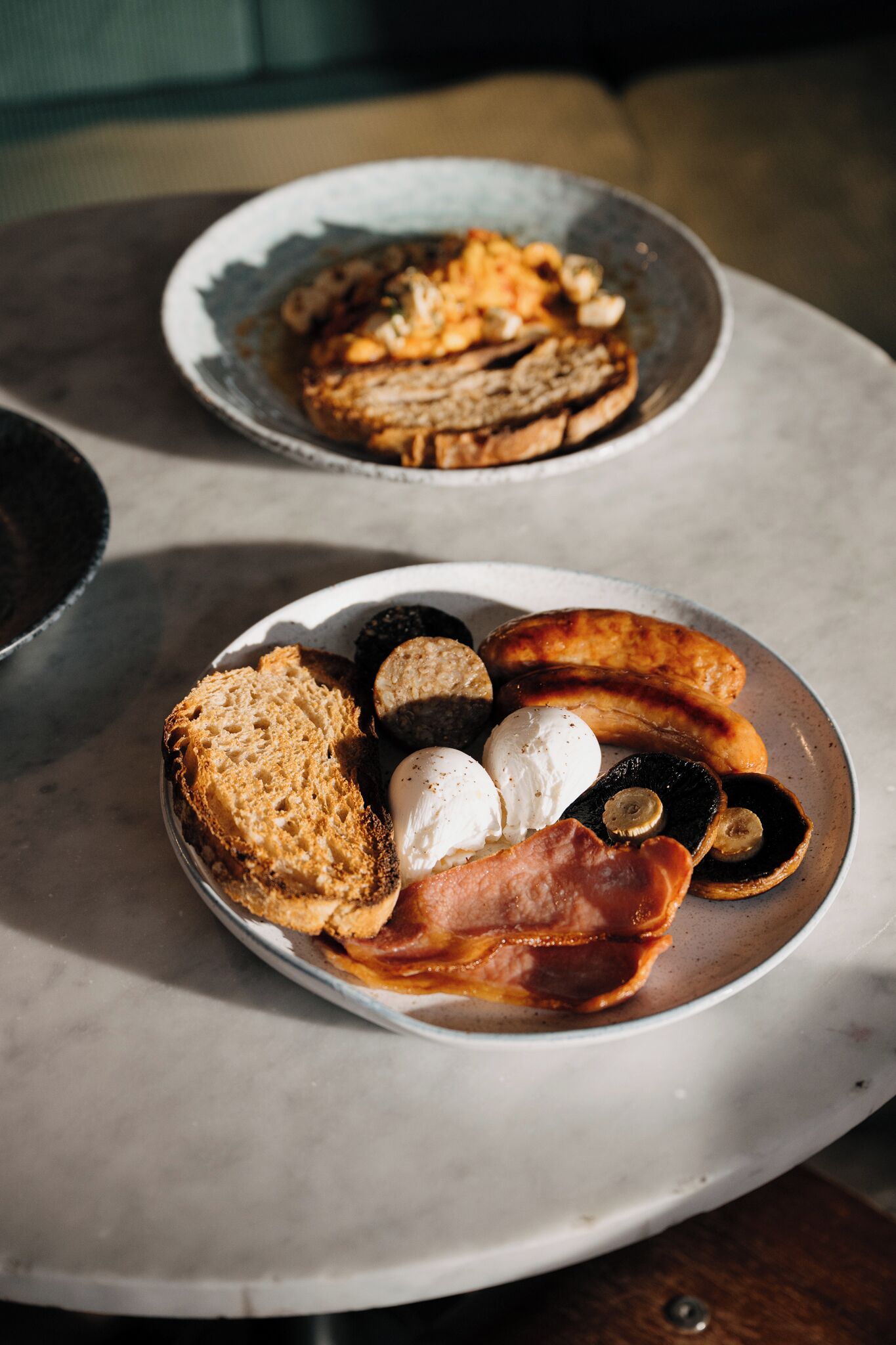 Dos platos de comida para el desayuno sobre una mesa de mármol.