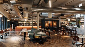 A restaurant interior with a bar area, seating arrangements, and visible kitchen equipment. - Bullitt Hotel (Belfast)