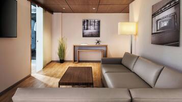 Uma sala de estar moderna com um sofá seccional, uma mesa de centro, um console com objetos decorativos e um quadro na parede.
