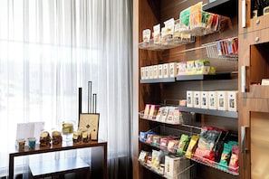 A well-organized pantry with shelves stocked with various food items and a table with jars and a framed picture.