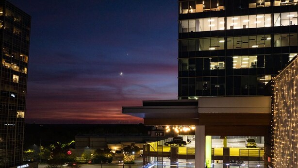 A rooftop bar with outdoor seating, surrounded by modern buildings and a view of the cityscape at dusk. - AC Hotel Raleigh North Hills (Raleigh)