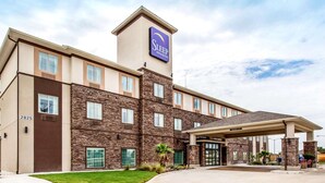 Edificio de Sleep Inn & Suites con fachada de piedra, múltiples ventanas y entrada cubierta.